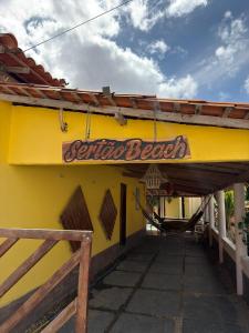 a yellow building with a sign for a seafood restaurant at Sertão beach in Tutóia +10 photos