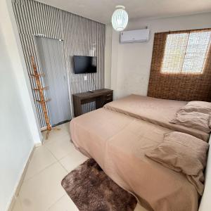 a bedroom with a bed and a television in it at Sertão beach in Tutóia