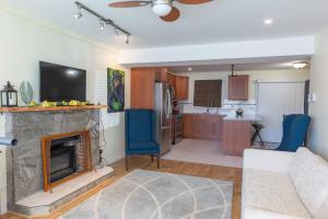 a living room with a fireplace and a kitchen at Langley Suite with Full Kitchen in Langley +10 photos