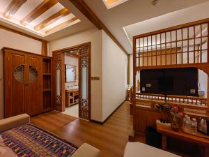 a living room with a flat screen tv and a living room at Shile Inn in Lijiang