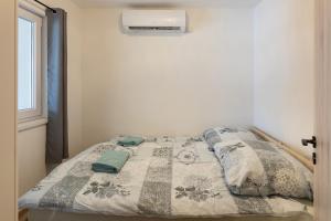 a bedroom with a bed with a blanket and a window at Zselic Kuckó by Mártika in Szigetvár