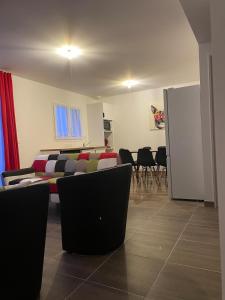 a living room with a couch and a table and chairs at Parenthèse 8 pers-6 mns Futuroscope-Famille in Chasseneuil-du-Poitou