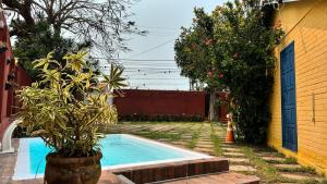 a small swimming pool in a yard next to a house at Iago Pousada in Cabo Frio