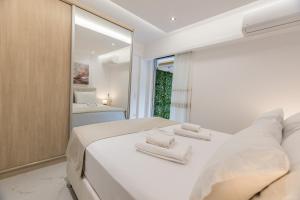 a bedroom with a white bed with towels on it at varkiza luxury 2BD apartment in Varkiza