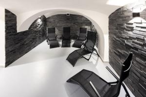 a room with black chairs and a brick wall at Vila Eduarda Grohmanna in Vrbno pod Pradědem