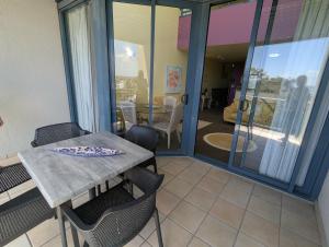 a table and chairs in a room with a balcony at Landmark Resort 518 - Casablanca Penthouse 5th Floor in Nelson Bay