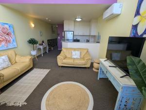 a living room with two couches and a kitchen at Landmark Resort 518 - Casablanca Penthouse 5th Floor in Nelson Bay