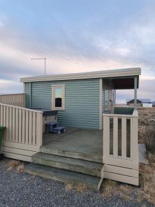 Ein grünes Minihaus auf einer Holzterrasse in der Unterkunft Old Cottage in Selfoss