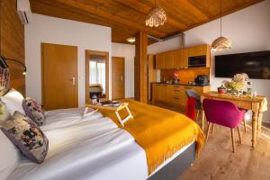 a bedroom with a large bed and a kitchen at APARTAMENTY U HARREGO BOUTIQUE SPA masaże, sauna, tężnia solankowa , balkon , taras , klimatyzacja , parking in Kudowa-Zdrój