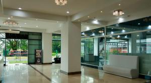 eine Lobby mit Glastüren und einem weißen Sofa in der Unterkunft Hotel Indigo in Barinas