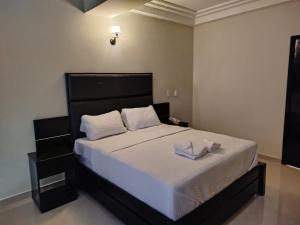 ein Schlafzimmer mit einem großen Bett mit schwarzem Kopfteil in der Unterkunft Hotel Indigo in Barinas