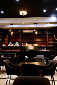 ein Restaurant mit Bar, Tischen und Stühlen in der Unterkunft Hotel Indigo in Barinas