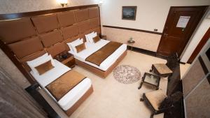 Draufsicht auf ein Schlafzimmer mit zwei Betten in der Unterkunft Orchid Inn by WIH in Karatschi