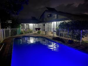 a swimming pool with blue lighting in front of a house at Matthys Guesthouse in Kimberley