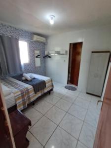 a bedroom with a bed and a bathroom at Apartamento Ryso do Mar Porto de Galinhas in Porto De Galinhas