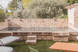 a stone retaining wall with a bench in a yard at Coudignac 1891 in Lagnes