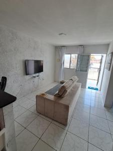 a living room with a couch and a flat screen tv at Apartamento Ryso do Mar Porto de Galinhas in Porto De Galinhas