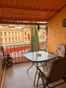 a balcony with a table and chairs and a view of a building at El Hogar de Carmelita in Guanajuato