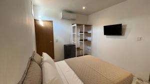 a bedroom with a bed and a tv on a wall at Casa Celisa in Cali