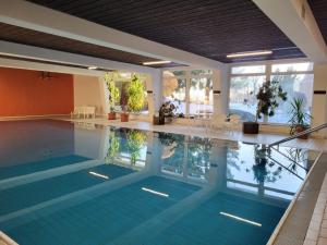 an indoor swimming pool with a large pool at Waldfeder Apartment mit Pool und Fitnessraum, neu und vollsaniert in Sankt Englmar