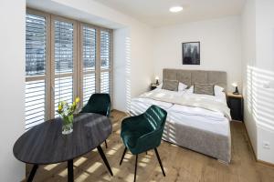 a bedroom with a bed and a table and chairs at Vila Eduarda Grohmanna in Vrbno pod Pradědem +56 photos