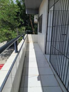 a walkway outside of a building with a fence at Apartamento Ryso do Mar Porto de Galinhas in Porto De Galinhas