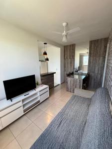 a living room with a flat screen tv and a couch at Apartamento prático e aconchegante - 5 min do Centro in Catanduva