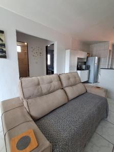 a living room with a couch and a kitchen at Apartamento Ryso do Mar Porto de Galinhas in Porto De Galinhas