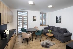 a living room with a couch and a table and chairs at Vila Eduarda Grohmanna in Vrbno pod Pradědem