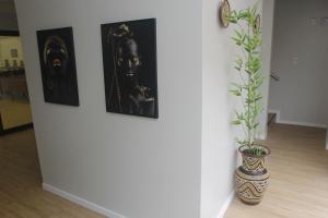 a wall with paintings and a vase with a plant at Centro de Formação in Belém