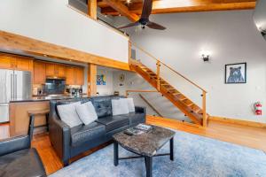 a living room with a couch and a staircase at Aspen Edge Lakefront and Loft in South Lake Tahoe