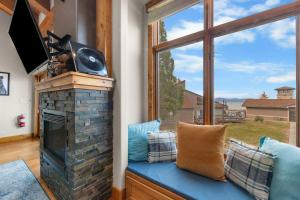 a living room with a fireplace and a large window at Aspen Edge Lakefront and Loft in South Lake Tahoe