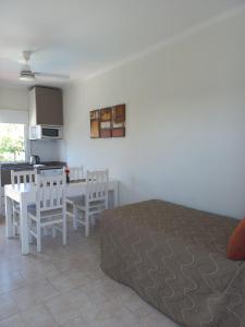 a bedroom with a bed and a table and a kitchen at Resort Termal Chajarí in Chajarí