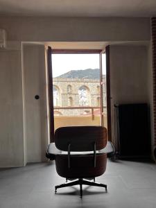 a black chair sitting in front of a window at hellofrom Tobacco Warehouse in Kavála
