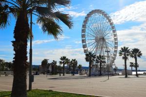 a ferris wheel in a park with palm trees at Dimora Cavour 1810 in Civitavecchia