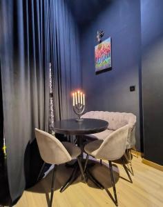 a dining room with a table and chairs with candles at KALI Old Town LOFT with Monument view in Bucharest
