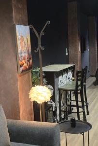 a living room with a bar with chairs and a table at KALI Old Town LOFT with Monument view in Bucharest