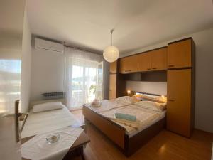 a bedroom with a large bed and a large window at Apartments Verdea in Kampor