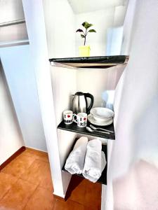 ein Regal in einem Zimmer mit einer Kaffeekanne und Handtüchern in der Unterkunft Donde Rafa in Maracay