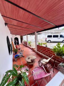 eine Terrasse mit rotem Dach, Stühlen und einem Tisch in der Unterkunft Donde Rafa in Maracay