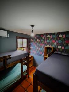 a room with two beds and a wall with umbrellas at Katsbarnea Hostel in Florianópolis
