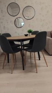 a dining room table with chairs and a mirror at Bella Apartment in Ruse