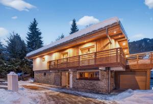 a log home with a large deck on the side of it at Luxury Chalet with Private Spa & Wellness Area in Megève