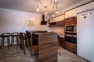 a kitchen with a counter and stools and a refrigerator at Ostrysz in Dzianisz
