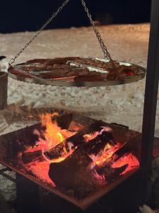 a plate hanging over a fire with a grill at Górska Chata w Górach Bystrzyckich in Niemojów