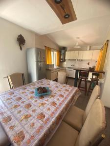 a kitchen and dining room with a table with a quilt on it at Casa los Churumbeles in Potrerillos