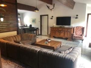 a living room with a couch and a table and a television at Roundstone View in Bewdley