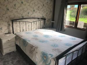 a bedroom with a bed and a dresser and a window at Roundstone View in Bewdley