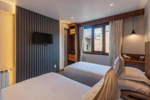 ein Hotelzimmer mit zwei Betten und einem Fernseher in der Unterkunft DREAM By Stannum Hotel in La Paz