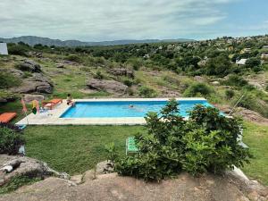 a swimming pool on a hill with people in it at Xaraba in Villa Parque Siquiman
